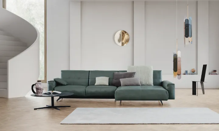 Rolf Benz green leather sectional sofa with chaise in a modern living room, showcasing premium sustainable furniture design.