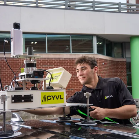 Engineer at Greentown Labs working with a drone and robotic cart to develop sustainable climate-tech hardware solutions